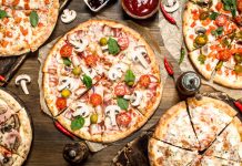 The Best Pizza Dough A variety of pizzas on a table as seen from above.