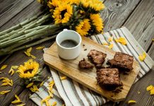 Cinnamon Brownies Cinnamon Brownies on a cutting board with a cup of coffee and sunflowers on the table.