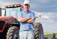 Understanding weather patterns can get you ahead in the fields Farmer standing by tractor