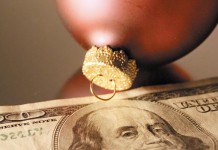 Seven simple ways to spend less this season Christmas bulbs and $100 bill