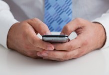 Lumosity to pay users for false claims man holding cell phone