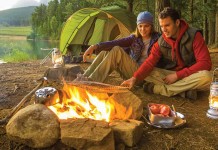 5 ideas for campfire cooking couple sitting by campfire