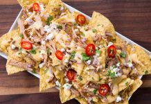 Pulled Pork Nachos Nachos covered in pulled pork, cilantro, peppers, cheese and other yummy toppings.