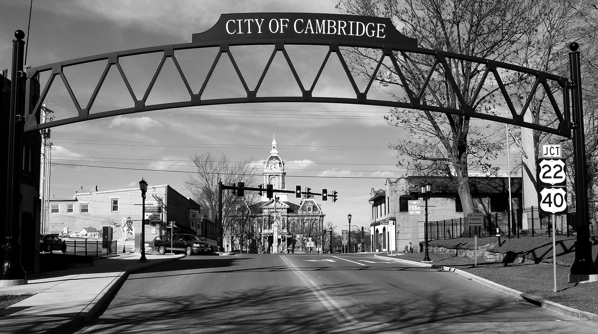 The entrance to the small town of Cambridge, a road leads up over a bride looking into this small town's historic distric. A church is seen in the distance.