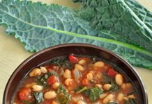 Kale and White Bean Soup A bowl of kale and white bean soup with Kale leaves in the background.