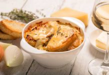 Slow Cooker French Onion Soup A bowl of French Onion Soup surrounded by onions, crostinis and cheese