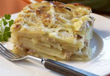 Potato and Swiss Cheese Gratin A serving of Potatoe & Swiss Cheese Au Gratin on a white plate with a sprig of parsley