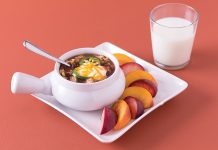 Slow Cooker Mexican Chicken Soup a bowl of Slow Cooker Mexican Chicken Soup, served with apple slices and a glass of milk.