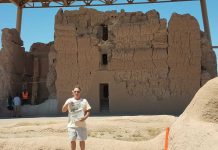 Visiting the Casa Grande Ruins with Bill Henry Bill Henry stands in front of the Casa Grande Ruins holding a Farm and Dairy newspaper.