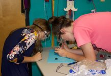 Breaking the cycle of limited broadband access, knowledge 4-H'ers work on a soldering activity at a club meeting.