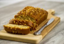 Gluten-Free Banana Bread Gluten-free banana bread loaf on a cutting block with a knife and two slices cut from the end.