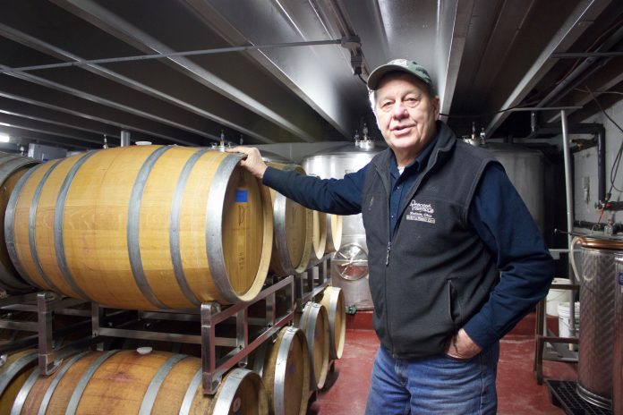 Tony Debevc, owner of Debonné Vineyards, in Madison, Ohio, stands in front of barrels of wine in the basement of the winery, Jan. 22.