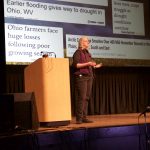 Experts advise ‘bounce forward’ on climate change A woman stands on a stage and speaks.