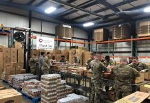 COVID-19 job loss creates overwhelming demand for food banks national guard members packing food