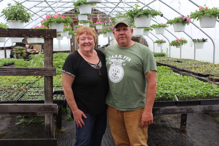 cathy and ken metrick stand in greenhouse