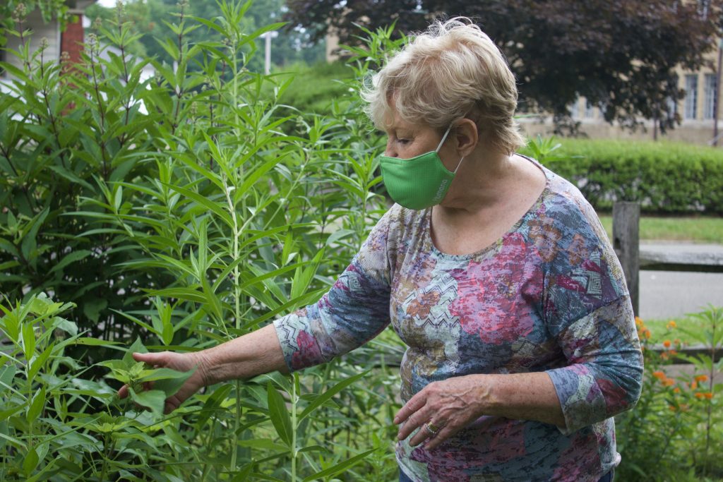 A woman stands in a garden.