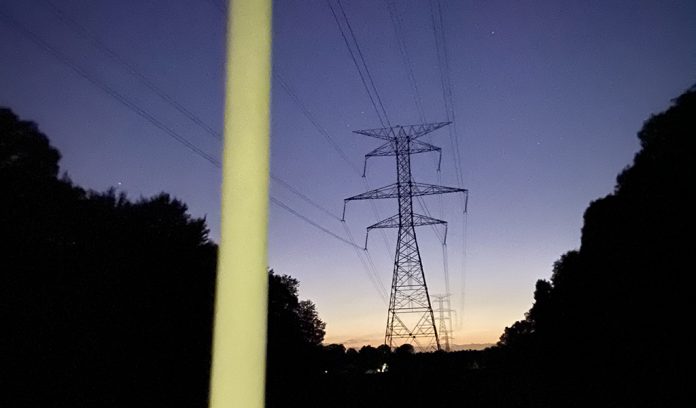 Fluorescent bulb glowing under power lines