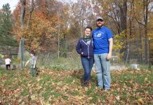 Home is where the mushrooms, microgreens are for Lorain Co. family A woman and a man stand in front of a garden in the fall while a girl and a boy play in the background.