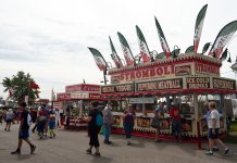 Ohio state legislature passes bill to reopen county fairs People walk around in front of concession stands at the Canfield Fair.