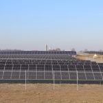 How a rural Ohio town is leading the way in clean energy solar panels sit in a field with a barn and silo in the background