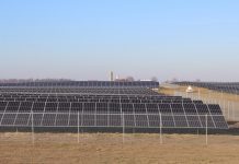 How a rural Ohio town is leading the way in clean energy solar panels sit in a field with a barn and silo in the background