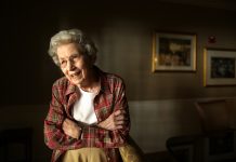 First female state 4-H leader Mildred Fizer celebrates 100th birthday A photo of Mildred Fizer, standing in a room in a red shirt.