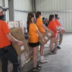 Troubled USDA food box program canceled volunteers hold boxes of food