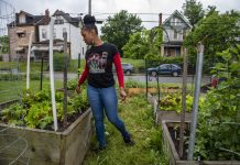 Discrimination adds a layer to beginning farmers’ challenges A woman stands in a garden at a community farm, in Pittsburgh.