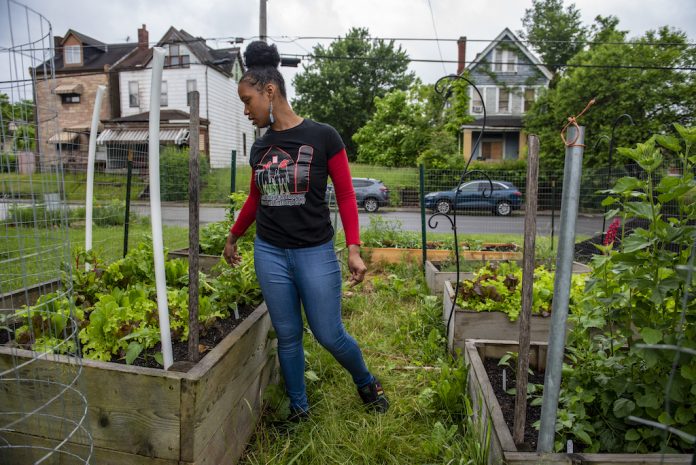 A woman stands in a garden at a community farm, in Pittsburgh.