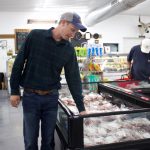 Rohr focuses on whole meat supply chain with Honeytown Meats A man looks over cuts of meat in a store.