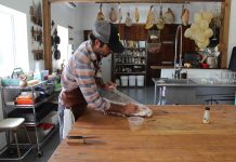 Hand Hewn Farm finds niche in hog butchering workshops guy wrapping up meat on a table