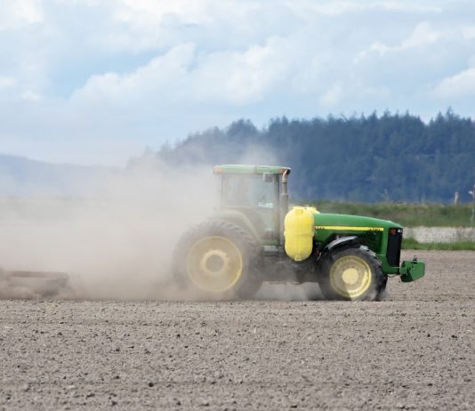 tractor stirring up dust in a field