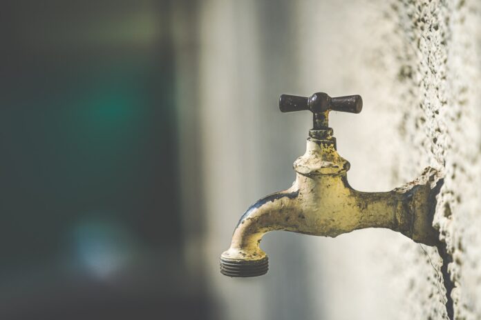 brass faucet with water droplets