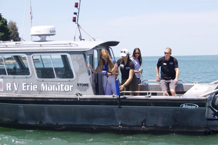 Researchers take water samples from a boat in Lake Erie