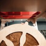 A replica of a sternwheel has a child's hand reaching to the top of it. 