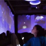 Full STEAM ahead: First children’s museum to open in Mid-Ohio Valley in April child looks at a blue interactive wall reflecting a water table