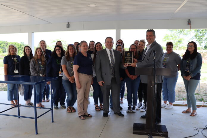 a group of teachers stand together to receive an award