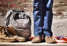 Proud veteran minimalist photography of person standing near backpack and boots