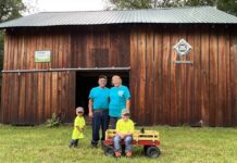 Schmuki family balances dairy farm, forestry on Ohio tree farm of the year A man, a woman and two boys stand in front of a barn.
