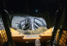 Do not thank a farmer the view from the seat of a skid steer, looking out onto a sea of large round hay bales wrapped in white plastic