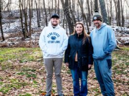 Tannar, Kimberly and Tom Barton stand in their backyard in Alicia, Pennsylvania on Dec. 7, 2025. The former Robena Coal Mine site is further up the hill.