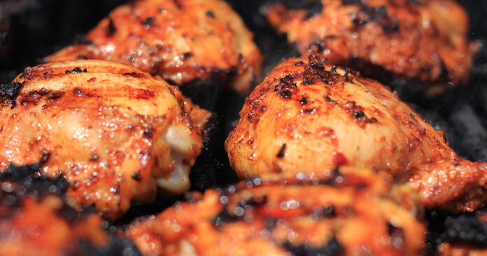 Delicious and juicy closeup of seasoned chicken thighs being coo