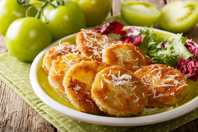 fried green tomatoes with fresh salad close-up on a plate and in