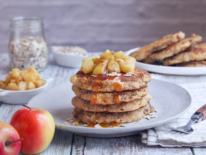 A plate of healthy rolled oat and apple pancakes topped with coo